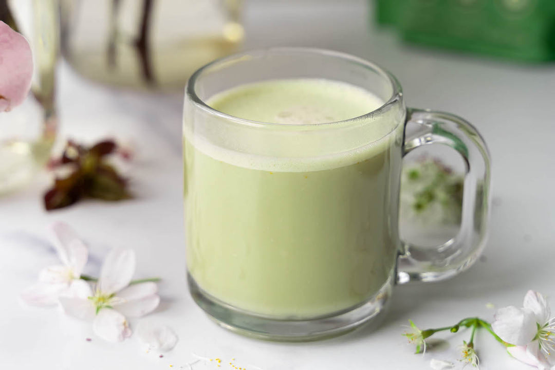 A matcha latte surrounded by spring flowers